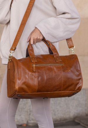 Braune Lederhandtasche mit zwei Griffen und einem abnehmbaren Schultergurt. Verfügt über eine Frontreißverschlusstasche und einen abgerundeten Boden mit schützenden Füßen.