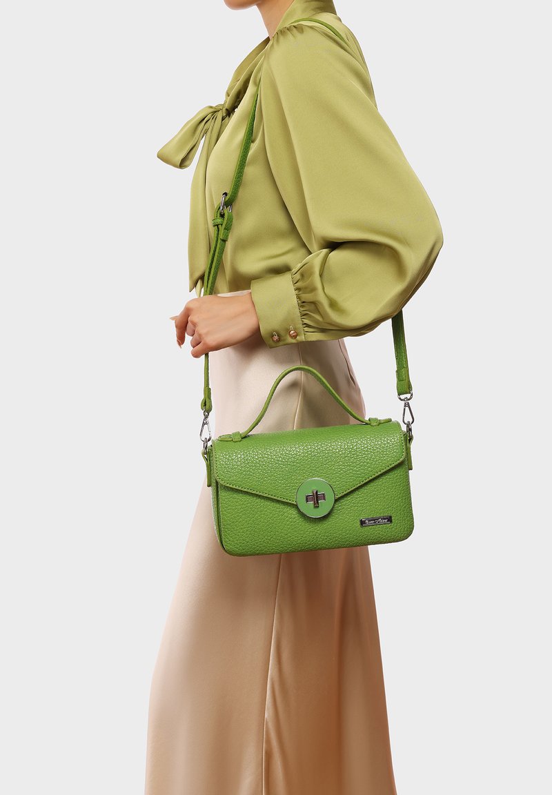 Borsa a tracolla in pelle verde testurizzata con chiusura a pattina, manico superiore e tracolla removibile. Presenta un dettaglio in metallo circolare e accenti metallici.