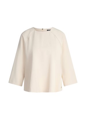 Crèmekleurige, losvallende top met 3/4 raglanmouwen, boothals en een onopvallende rits aan de achterkant. Glad materiaal met een subtiele glans.