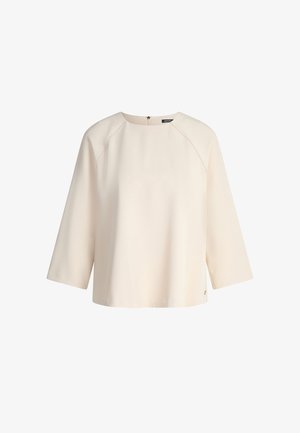 Cremefarbenes, locker sitzendes Oberteil mit 3/4-Raglanärmeln, Bootsausschnitt und einem dezenten Reißverschluss am Rücken. Glatter Stoff mit dezentem Glanz.