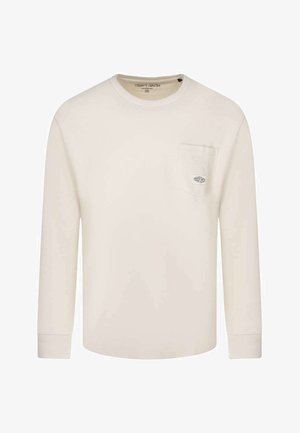 Chemise à manches longues couleur crème avec encolure ronde et poche poitrine ornée d'un petit patch logo rectangulaire.