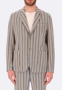 Blazer a righe realizzato in tessuto leggero, con righe verticali di colore beige chiaro, blu navy e bianco, due tasche anteriori e revers a scalfo.