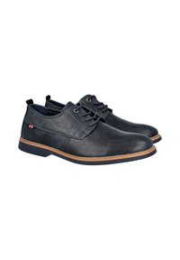 Zapatos de cuero negro con punteras redondeadas, diseño con cordones, detalles en azul y suela de goma marrón. Presentan un pequeño logo en el lateral.