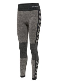Grå atletiska leggings i strukturerad tyg, med en svart midja och ett kontrasterande svart chevronmönster längs sidorna.