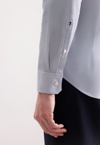 Camicia blu e bianca con motivo, realizzata in tessuto strutturato, con dettagli sui polsini a bottoni e una vestibilità su misura, con un finish liscio sulle maniche.