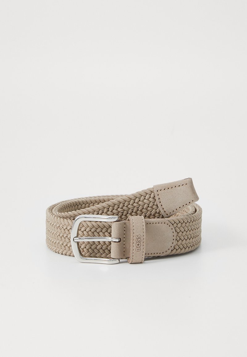 Beige vævet stofbælte med en mat sølvspænde, læderdetaljer og syede detaljer. Fleksibelt design med justerbar pasform.