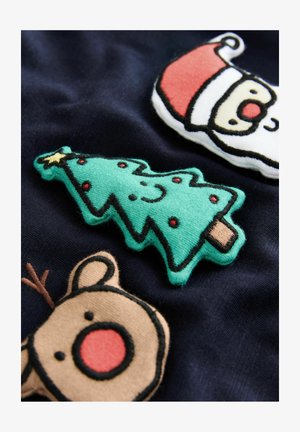 Sretno zeleni božićni drvce, irvasi s crvenim nosom i božićna lica na tamnom platnu, svečana blagdanska dekoracija.