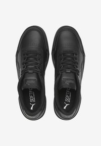 Chaussures de sport noires avec une tige en cuir lisse, fermeture à lacets, design perforé à l'avant, et semelle intérieure rembourrée. Logo Puma à l'intérieur.