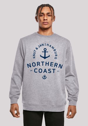 Grauer Sweatshirt mit grafischem Design in Marineblau, das einen Anker und den Text "NORTHERN COAST" zeigt, zentriert auf der Vorderseite. Glatte Textur, gerippte Bündchen.