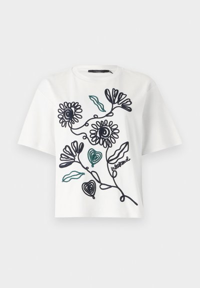 White cotton t-shirt with short sleeves featuring black line drawings of flowers and leaves, highlighted with green stitching.