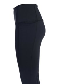 Leggings negros con cintura alta, textura suave y costuras en contraste. Presentan un corte ajustado y detalle de bolsillo lateral.