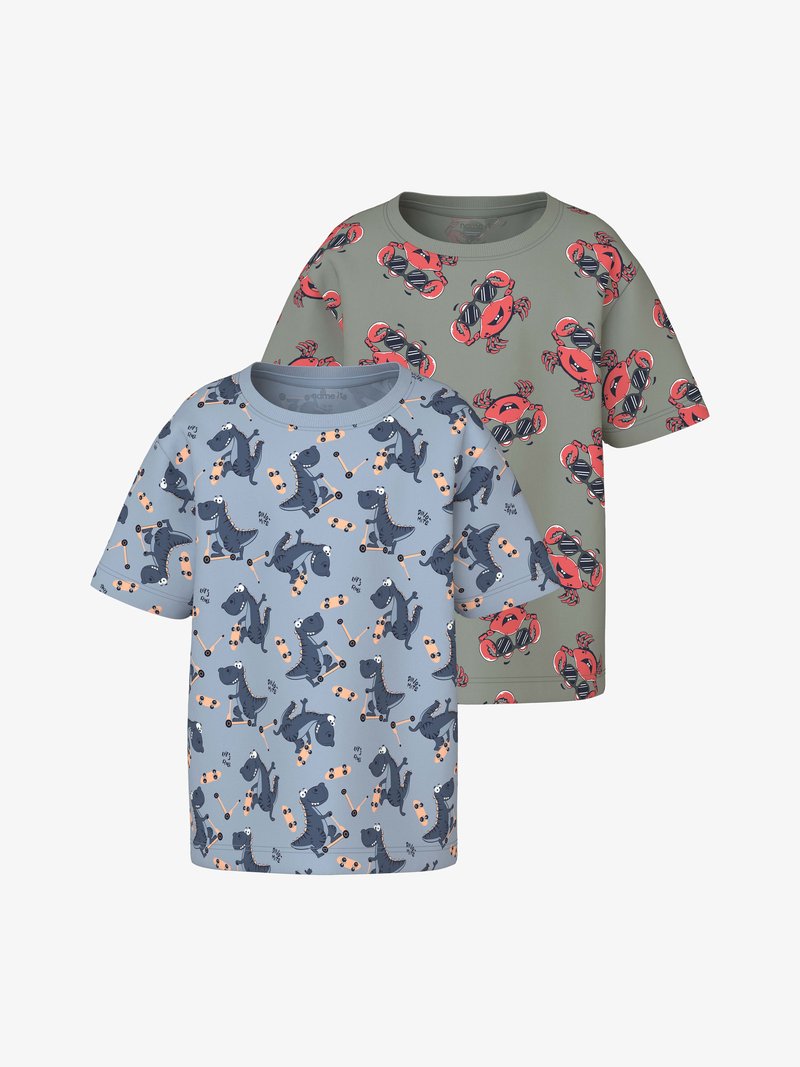 Δύο παιδικά κοντομάνικα μπλουζάκια, ένα πράσινο με κόκκινα καβούρια που φοράνε γυαλιά ηλίου και ένα μπλε με σκούρους μπλε δεινόσαυρους που κάνουν σκέιτμπορντ.