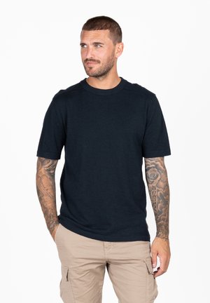 Navyblauwe katoenen t-shirt met korte mouwen, ronde hals en een gladde textuur. Voorzien van subtiele stiksels op de schouders.