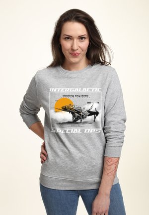 Grauer Sweatshirt mit einem Grafikdruck eines Raumschiffs und der Sonne. Lange Ärmel mit gerippte Bündchen und Saum. Der Text lautet "INTERGALACTIC SPECIAL OPS."