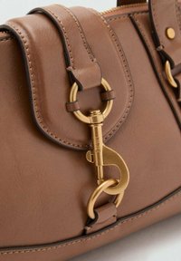 Brown leather handbag with a textured finish, featuring a gold-tone clasp and circular hardware, accentuating its structured design.