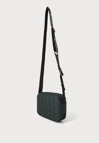Borsa a tracolla verde con motivo, forma rettangolare, chiusura con zip, tracolla nera regolabile e finitura opaca.