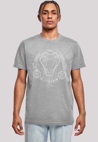 Pilkas medvilninis marškinėliai su baltu Slytherin gyvatės logotipu ir tekstu. Trumpomis rankovėmis ir apvaliu iškirpimu, su laisvu siluetu.