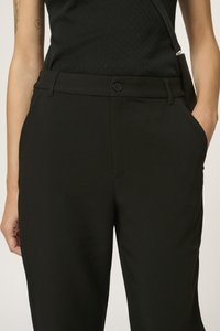 Black tailored pants with a smooth texture, featuring a button closure and side pockets. The fabric has a sleek, professional appearance.