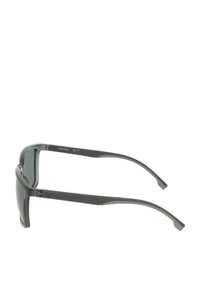 Occhiali da sole neri di forma rettangolare con lenti scure, montatura in plastica leggera e aste angolari. Dettaglio del logo ben visibile all'interno dell'asta.