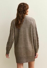 Abito maglione in marrone con maniche a trecce, orlo a coste e vestibilità ampia. Materiale testurizzato con un aspetto accogliente, progettato per il comfort.