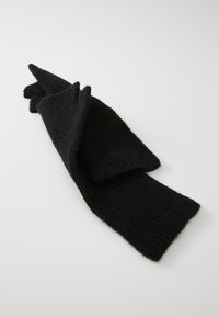 Écharpe en tricot noire, tissu texturé avec un motif côtelé, forme rectangulaire longue, pliée soigneusement avec des extrémités pointues.