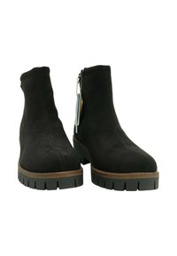 Botines de ante negro con suelas gruesas de tacos, ribete marrón y cremalleras laterales, colocados de frente sobre un fondo blanco.