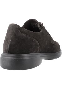 Scarpa in suede nera con punta arrotondata, superficie testurizzata e suola in gomma nera. Presenta un design con lacci e dettagli di cucitura minimi.