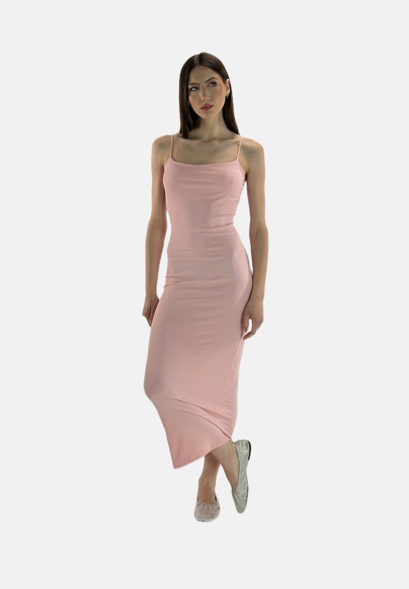 Lichtroze, aansluitende camisole-maxijurk met spaghettibandjes, zachte textuur en een lichte drape. Draagt met sprankelende platte schoenen.