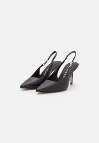Tacchi a slingback neri con punta appuntita, realizzati in pelle liscia, con tacco sottile e un'accattivante accentatura in oro sulla cinghia.