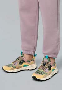 Sneaker multicolori con un mix di motivi, tra cui una stampa leopardata verde. Il design include una tomaia in rete nera e una suola maculata.
