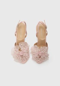 Pink high-heeled sandals with a ruffled tulle bow, adorned with pearls, open toe design, and adjustable ankle strap.