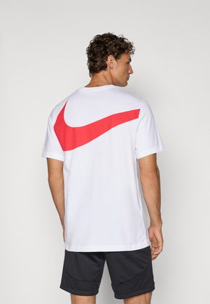 White short-sleeve t-shirt featuring a large red Nike swoosh logo on the back. The fabric appears smooth, with a relaxed fit.