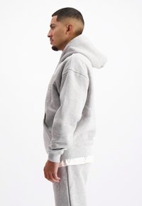 Grijze hoodie met kangoeroe pocket, geribbelde manchetten en tailleband; met een zachte textuur en een relaxed fit.
