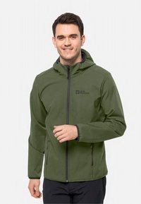 Veste softshell verte avec capuche, dotée d'une fermeture éclair sur le devant et de poches latérales, accents noirs et logo sur la poitrine gauche.