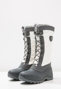 Botas de nieve grises y blancas con parte superior acolchada, borde de piel sintética y cordones redondos. Suela de goma texturizada para tracción y estabilidad.