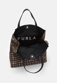 Sac cabas Furla avec un extérieur à motif en noir et moutarde. Design ouvert mettant en valeur un intérieur noir avec un imprimé logo et une fermeture à pression.