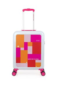 Maleta rígida blanca con un vibrante patrón geométrico en rosa, naranja y rojo. Cuenta con un mango retráctil rosa y ruedas.