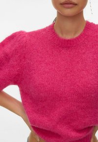 Pull en tricot fuchsia avec manches courtes bouffantes et encolure ronde. Texture douce, coupe décontractée et détail de bande côtelée à l'ourlet.