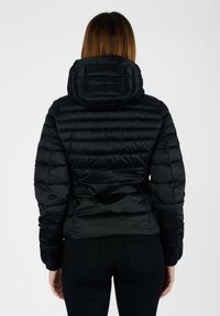 Giubbotto imbottito nero con cappuccio, caratterizzato da un design trapuntato e polsini elasticizzati. Materiale liscio e lucido con una silhouette aderente in vita.
