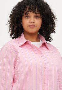 Ροζ πουκάμισο με κουμπιά, με λευκές και λεβάντες ρίγες. Διαθέτει κλασικό γιακά, χαλαρή εφαρμογή και υφασμάτινη βαμβακερή υφή.