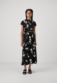 Melnas ziedu kleitas ar īsām piedurknēm, izceltu vidukli un plūstošu A-formas siluetu. Satur smilškrāsas ziedu rakstus un apkakli.