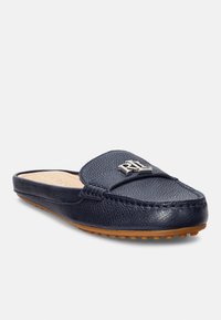 Jūras zila ādas slip-on kurpe ar teksturētu virsmu, šūtu dizainu un metāla logotipa akcentu. Mīksta iekšzole ar gumiju izgatavotu zolīte.