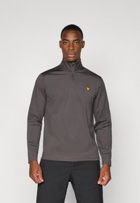 Grå zip-neck pullover lavet af glat stof, med lange ærmer og et lille gult fuglelogo på venstre bryst.