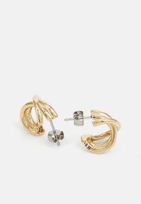 Boucles d'oreilles dorées avec un design sculptural en torsion. Présentent des tiges argentées et de petits accents colorés sur une des boucles.