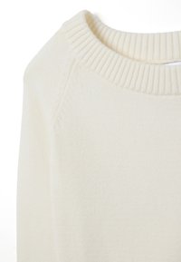 Cremfarbener Pullover mit geripptem Kragen, weichem Material und entspanntem Schnitt. Verfügt über Raglanärmel und ein minimalistisches Design.