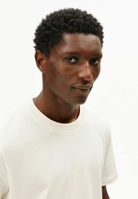 Wit katoenen T-shirt met een ronde hals, korte mouwen en een gladde textuur, weergegeven tegen een neutrale achtergrond.