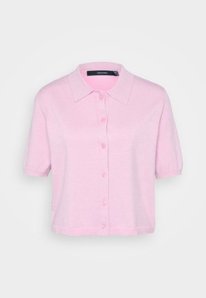 Camisa rosa de manga curta com colarinho pontudo, feita de um tecido texturizado e brilhante. Apresenta cinco botões a condizer na frente.