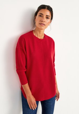 Red ribbed sweater with a round neckline and long sleeves. The fabric appears soft, featuring a slightly loose fit and a curved hem.