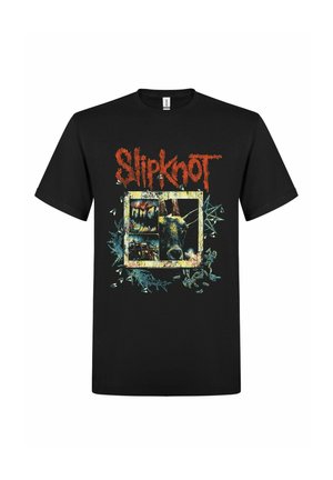 Camiseta negra con texto rojo "Slipknot" encima de un gráfico de una cara de animal gruñendo y formas abstractas dentro de un marco cuadrado irregular.