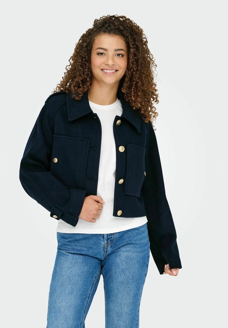 Marineblå cropped jakke lavet af uld med en struktureret design, der har guldknapper, store frontlommer og en krave-nakke.